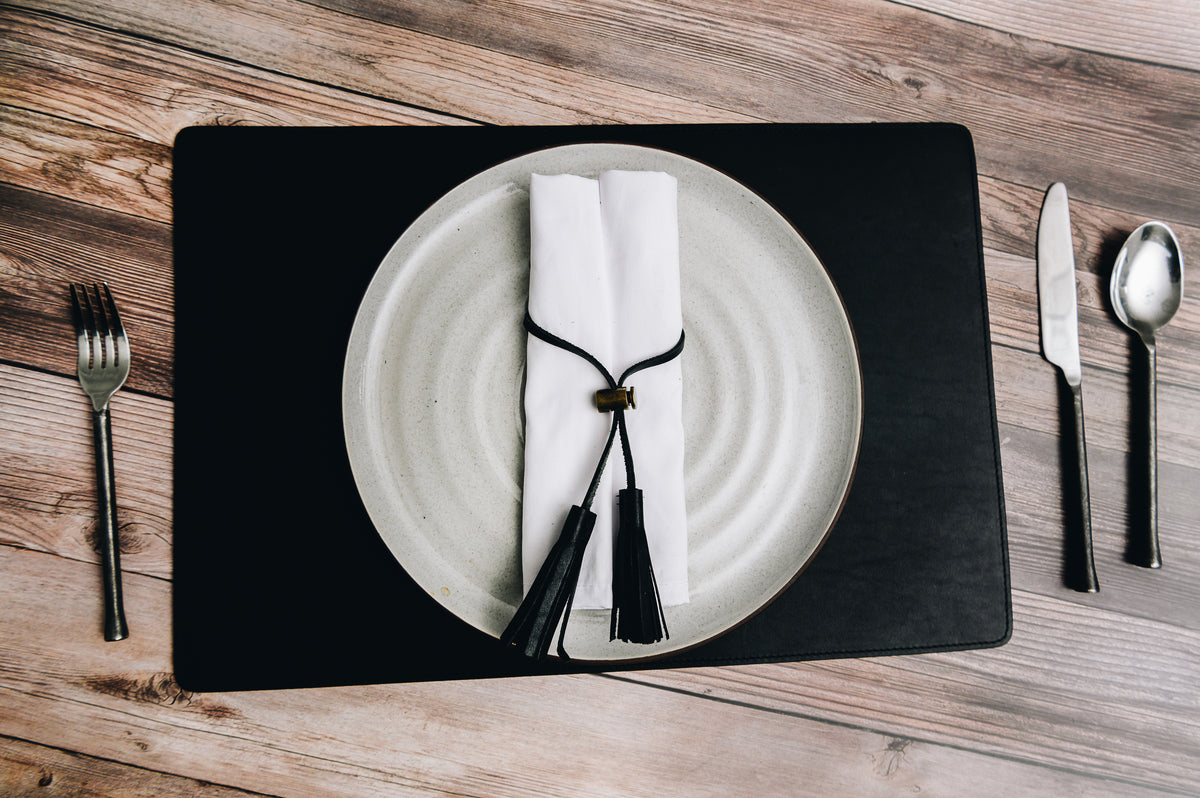 Add elegance to your dining table with the Nash leather placemat. Available in three classic, neutral colors, the Nash leather placemat is backed with a non-skid durable rubber mat. #color_black