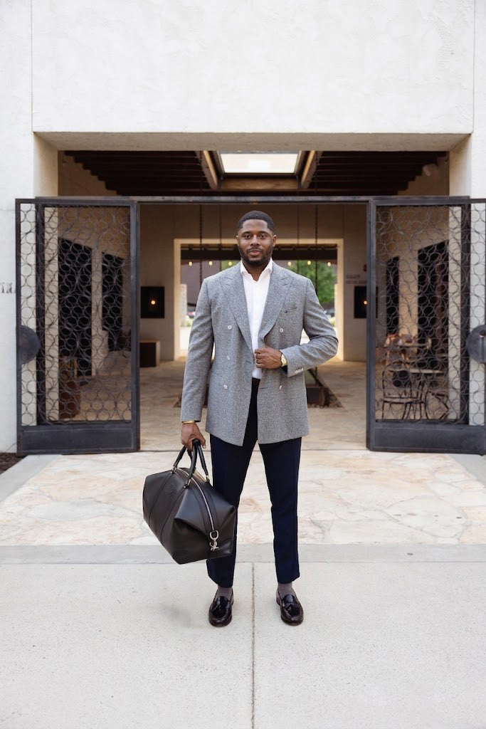 Stylish man with black leather duffel bag