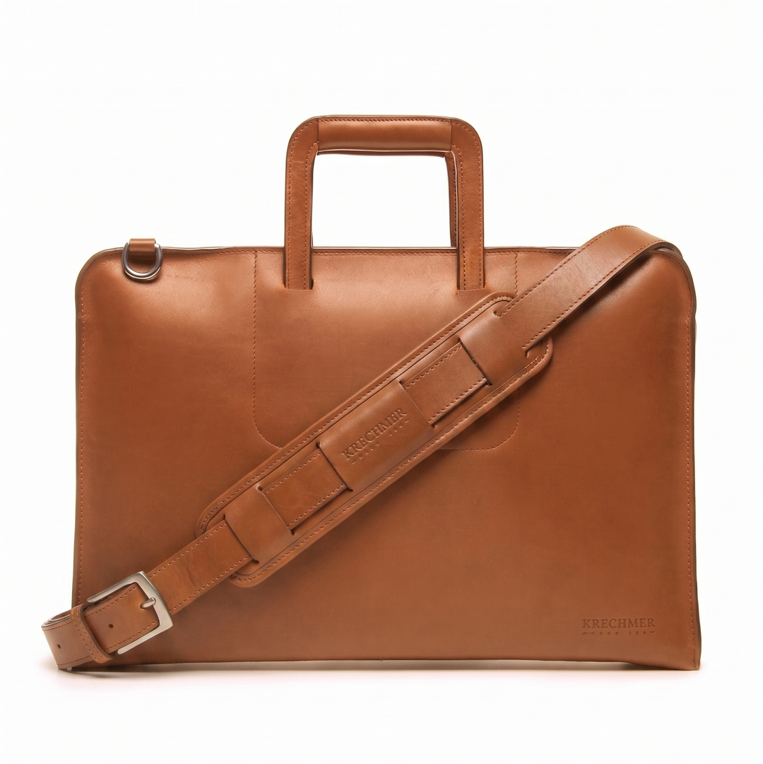 Tan Full grain mill dyed American leather exterior and interior Telescoping handles allow for easy access to interior easy underarm carry Cell phone, tablet, pen and notebook pockets Solid Brass hardware in matte nickel finish Full length solid brass polished tooth zipper allowing lay flat use Adjustable, removable shoulder strap Handcrafted in our own factory Removable, padded computer sleeve designed for most 15" laptops Dimensions: 17" x 3" x 11.5" #color_tan