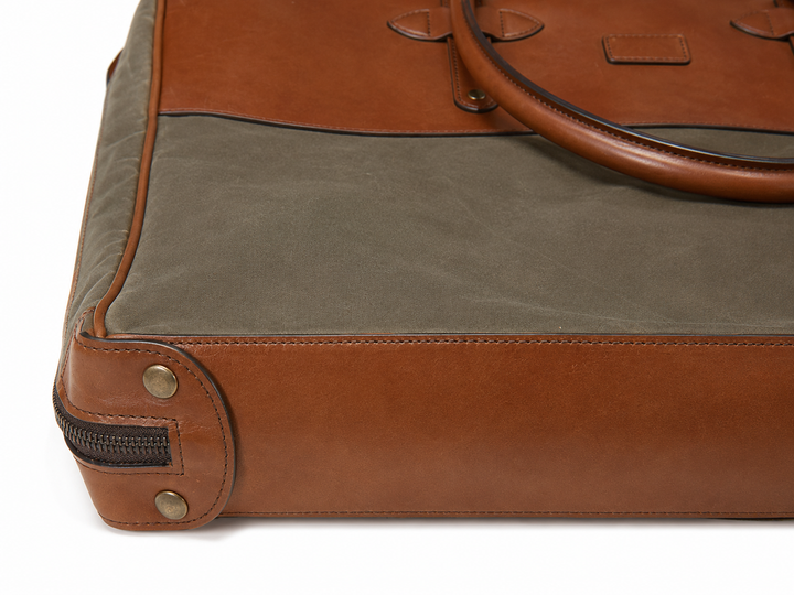 Olive Close-up of the Prescott garment bag reinforced leather base, zipper, stitching, and metal feet