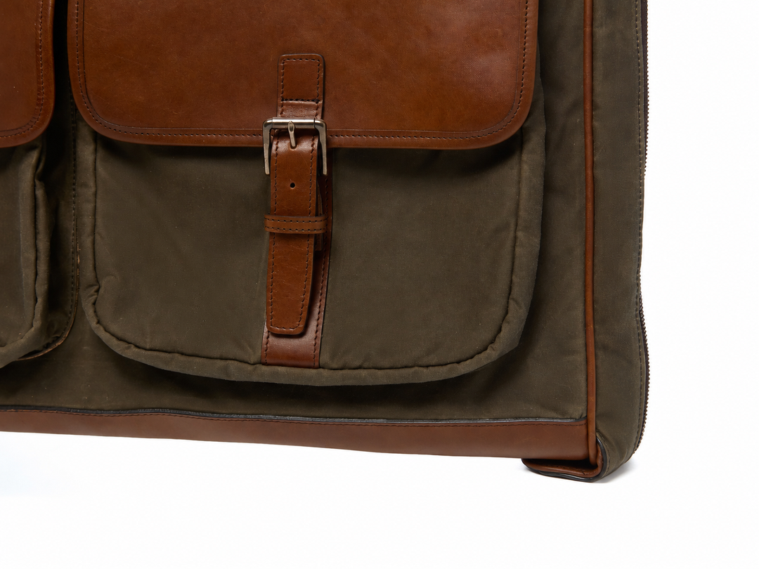 Olive Close-up of the Prescott garment bag exterior pocket, leather buckle strap, and reinforced lower corner