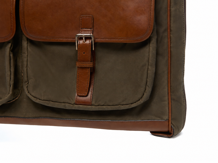 Olive Close-up of the Prescott garment bag exterior pocket, leather buckle strap, and reinforced lower corner