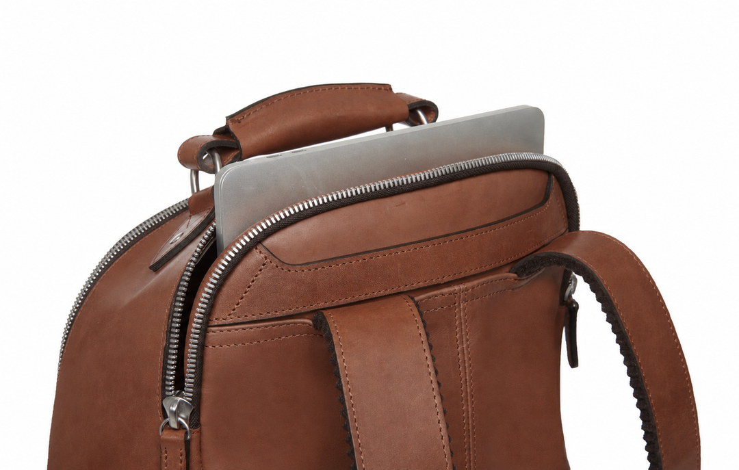 Brown Handcrafted with full grain American leather Padded backpack shoulder straps Roomy interior and front pocket Keychain attachment Interior organizer panel Fits up to a 15" laptop  Strap designed for easy carry on telescoping luggage handles Handcrafted with care in our own factory Natural leather lining Dimensions: 17" x 7" x 12" #color_brown