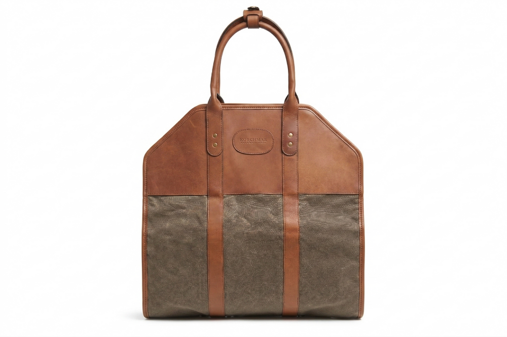 Brown and beige leather bag with a handle on a white background Olive Waxed canvas log carrier Carry logs from the wood pile into your home in style and with ease using the Rayburn waxed canvas log carrier. The Rayburn is expertly constructed with multiple layers of 8.25 oz waxed canvas and is trimmed in full-grain American leather. #color_olive