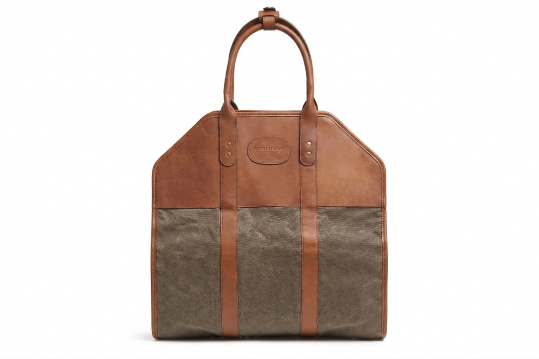 Brown and beige leather bag with a handle on a white background Olive Waxed canvas log carrier Carry logs from the wood pile into your home in style and with ease using the Rayburn waxed canvas log carrier. The Rayburn is expertly constructed with multiple layers of 8.25 oz waxed canvas and is trimmed in full-grain American leather. #color_olive