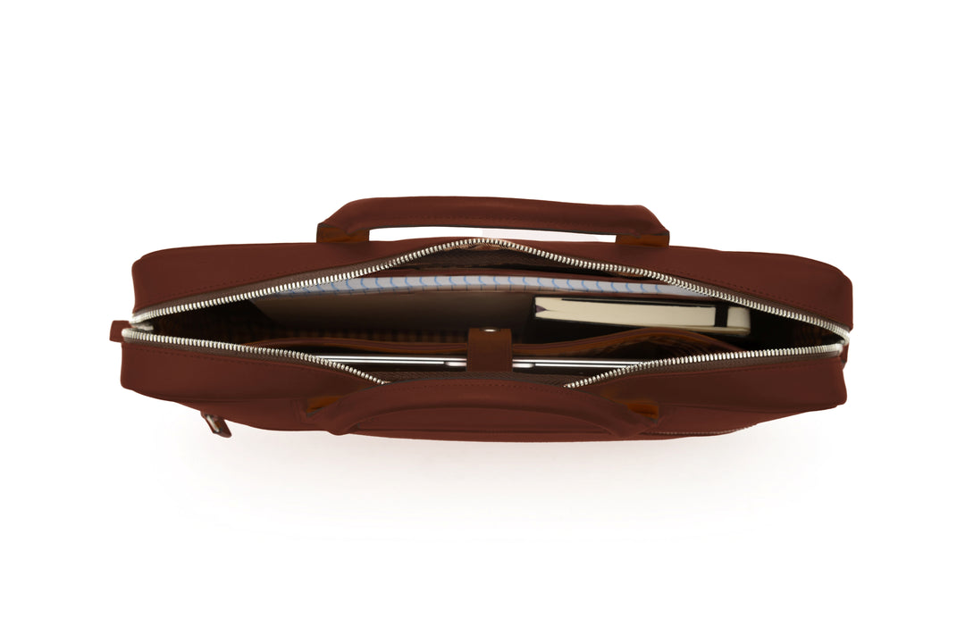 Brown Full-grain mill dyed American saddle leather Solid brass hardware in matte nickel finish Solid brass polished tooth zipper Removable, adjustable shoulder strap with ergonomic pad Front zippered and slim literature pocket on the back Removable, snap-in key chain Padded interior computer pocket Fully lined with signature 6.4 oz yarn dyed twill Carry bag strap slide over telescoping luggage handle Handcrafted with care in our own factory Fits most 15" laptops #color_brown
