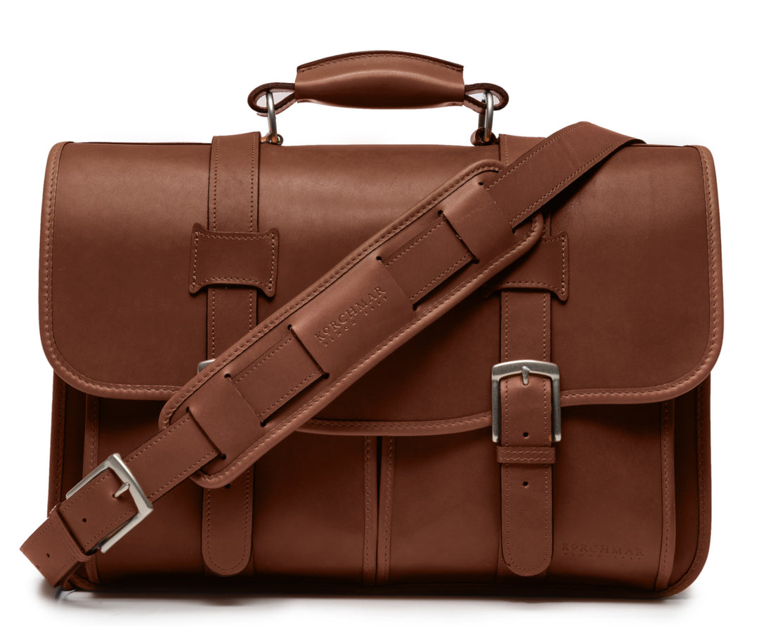 Brown Exterior back pocket and zipped interior pocket Pillow soft padded leather handle Removable, adjustable shoulder strap with ergonomic pad Carry bag strap to slide over telescoping luggage handle Protective laptop compartment Handcrafted with care in our own factory Fits up to a 15" laptop Dimensions: 16.5" x 6" x 13" #color_brown
