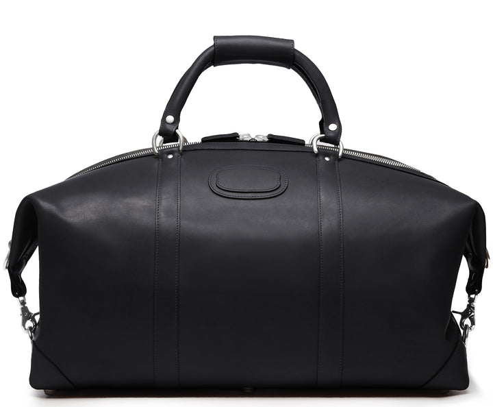 Black 22" Leather Weekender  The Twain weekender in Korchmar's Classic Leather is made of American cowhide leather that is selected from the top 5% of available hides. Colored only with aniline dyes, this leather retains its natural beauty over time and features visible markings that are characteristic of only the finest leather. One of our best-selling weekender styles, the Twain is ideal for leisure or business travel. #color_black