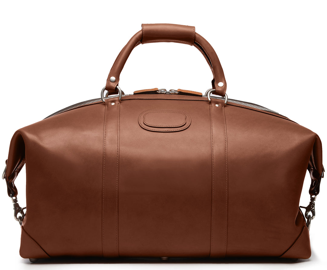 Brown 22" Leather Weekender  The Twain weekender in Korchmar's Classic Leather is made of American cowhide leather that is selected from the top 5% of available hides. Colored only with aniline dyes, this leather retains its natural beauty over time and features visible markings that are characteristic of only the finest leather. One of our best-selling weekender styles, the Twain is ideal for leisure or business travel. #color_brown