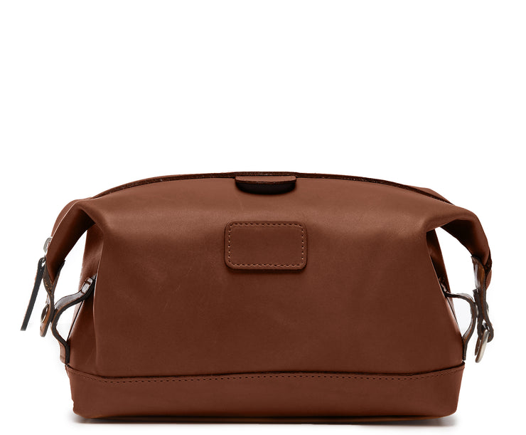 Brown Leather Dopp Kit The Ryder dopp kit in Korchmar's Classic Leather is made of American cowhide leather that is selected from the top 5% of available hides. Colored only with aniline dyes, this leather retains its natural beauty over time and features visible markings that are characteristic of only the finest leather. The Ryder features a top zipper and snap down ends that allow for maximum expansion.