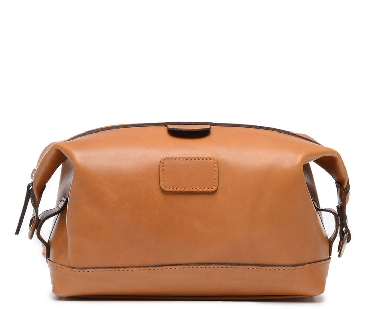 Tan Leather Dopp Kit The Ryder dopp kit in Korchmar's Classic Leather is made of American cowhide leather that is selected from the top 5% of available hides. Colored only with aniline dyes, this leather retains its natural beauty over time and features visible markings that are characteristic of only the finest leather. The Ryder features a top zipper and snap down ends that allow for maximum expansion.