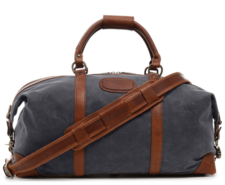 Grey Premium waxed canvas with full grain American leather trim Antiqued solid brass hardware Unique "clamp down" ends allow roomy main compartment to expand Fully lined with signature 6.4 oz yarn dyed twill Interior zippered pockets Removable, adjustable shoulder strap with ergonomic pad Customizable monogram patch on exterior Handcrafted with care in our own factory Dimensions: 22" x 10" x 14" #color_grey