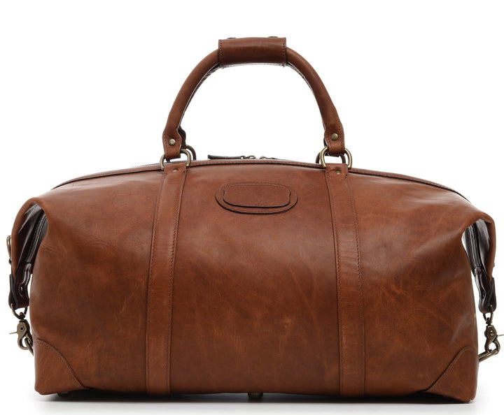 Espresso 22" Leather Weekender One of our best-selling weekender styles, the Twain is ideal for leisure or business travel. At 22", it is designed to fit comfortably in most airline overhead compartments. The Twain leather duffel bag is handcrafted in the USA with full grain leather that develops a beautiful patina with time. It includes a removable, adjustable shoulder strap. #color_espresso